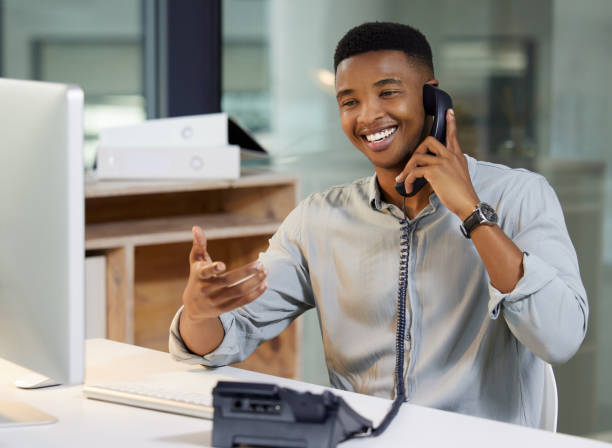 young man behind a computer on the phone giving customer support