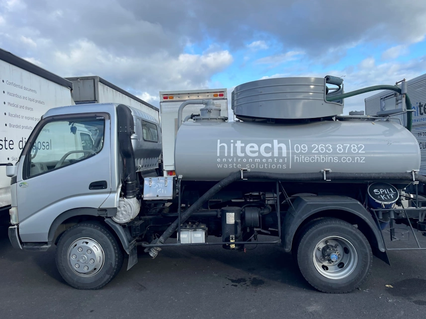 gray hitech liquid waste disposal truck with hoses visible